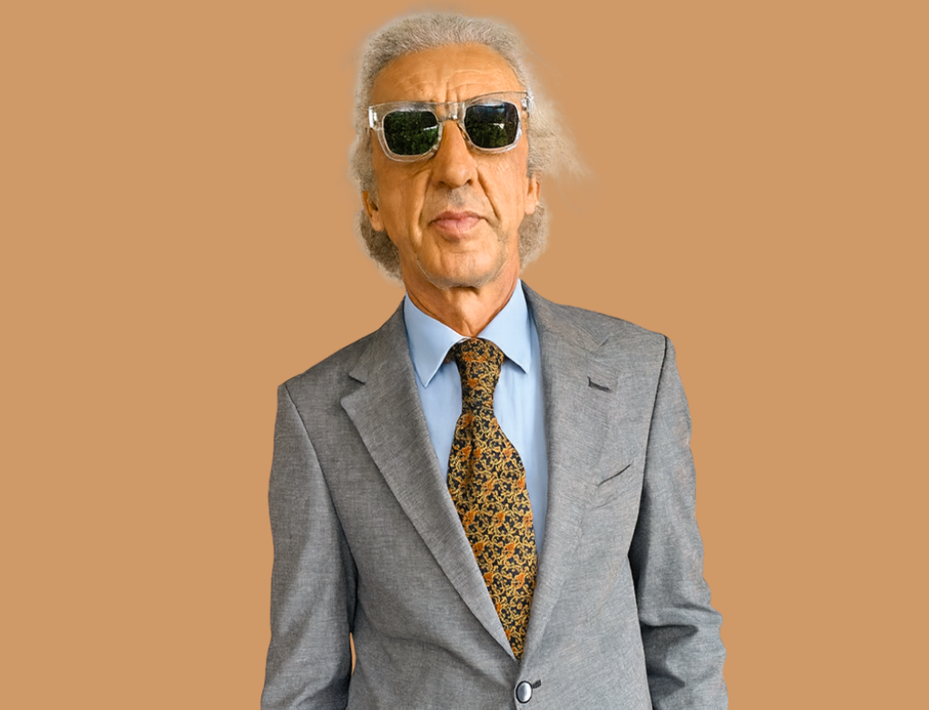 Man wearing a gray suit with a patterned tie on a brown background