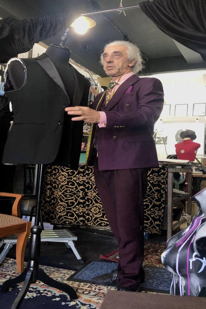 Detailed view of traditional canvas suit construction and tailoring tools on a workshop table.
